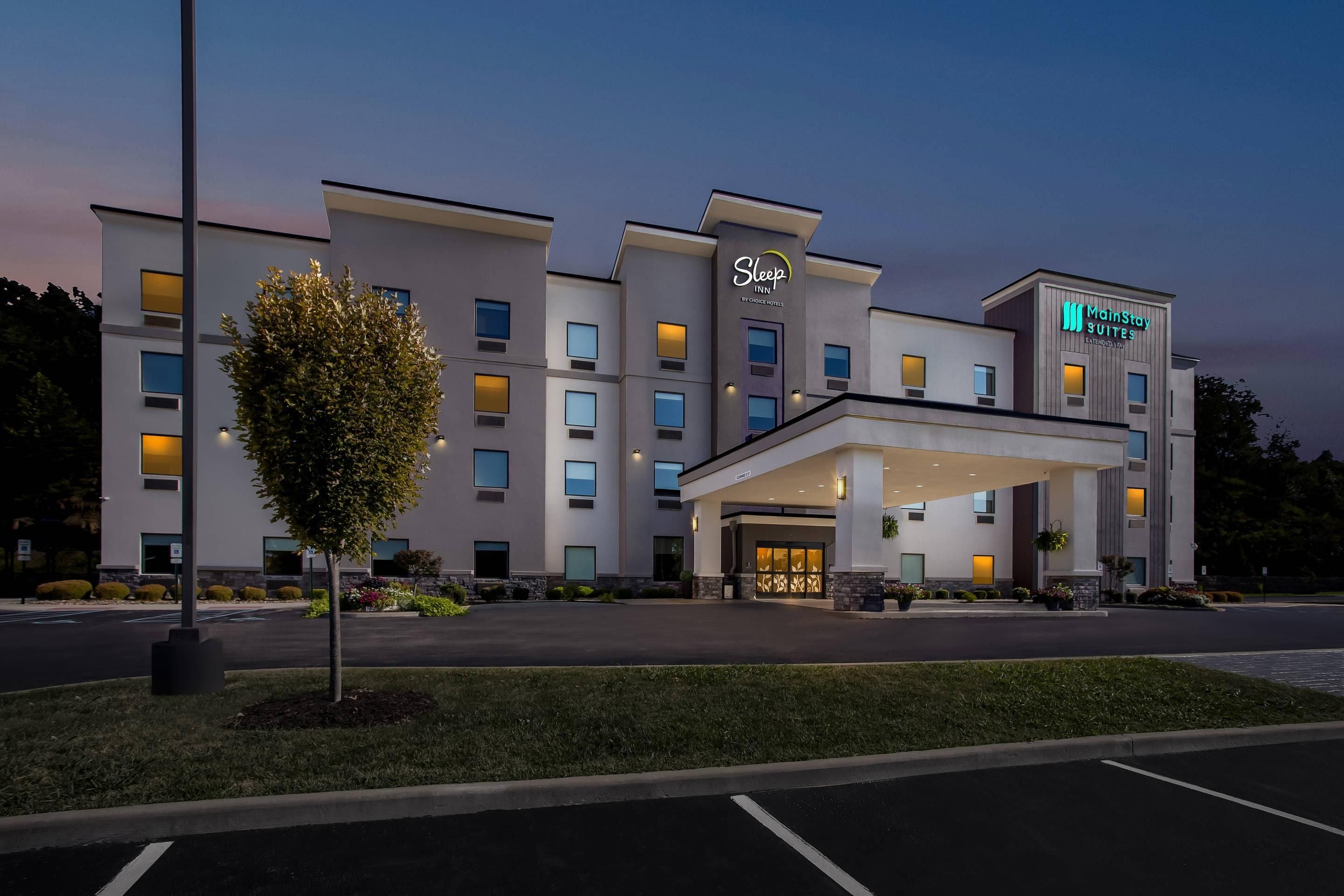 A Sleep Inn hotel with a modern facade, multiple entry points, and a well-lit entrance.