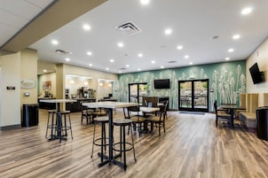 Un restaurante moderno con suelo de madera, taburetes de bar y una zona de mostrador.