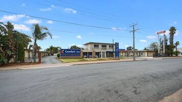 Un motel Comfort Inn avec une enseigne, un bâtiment doté d’un balcon et un ciel dégagé.