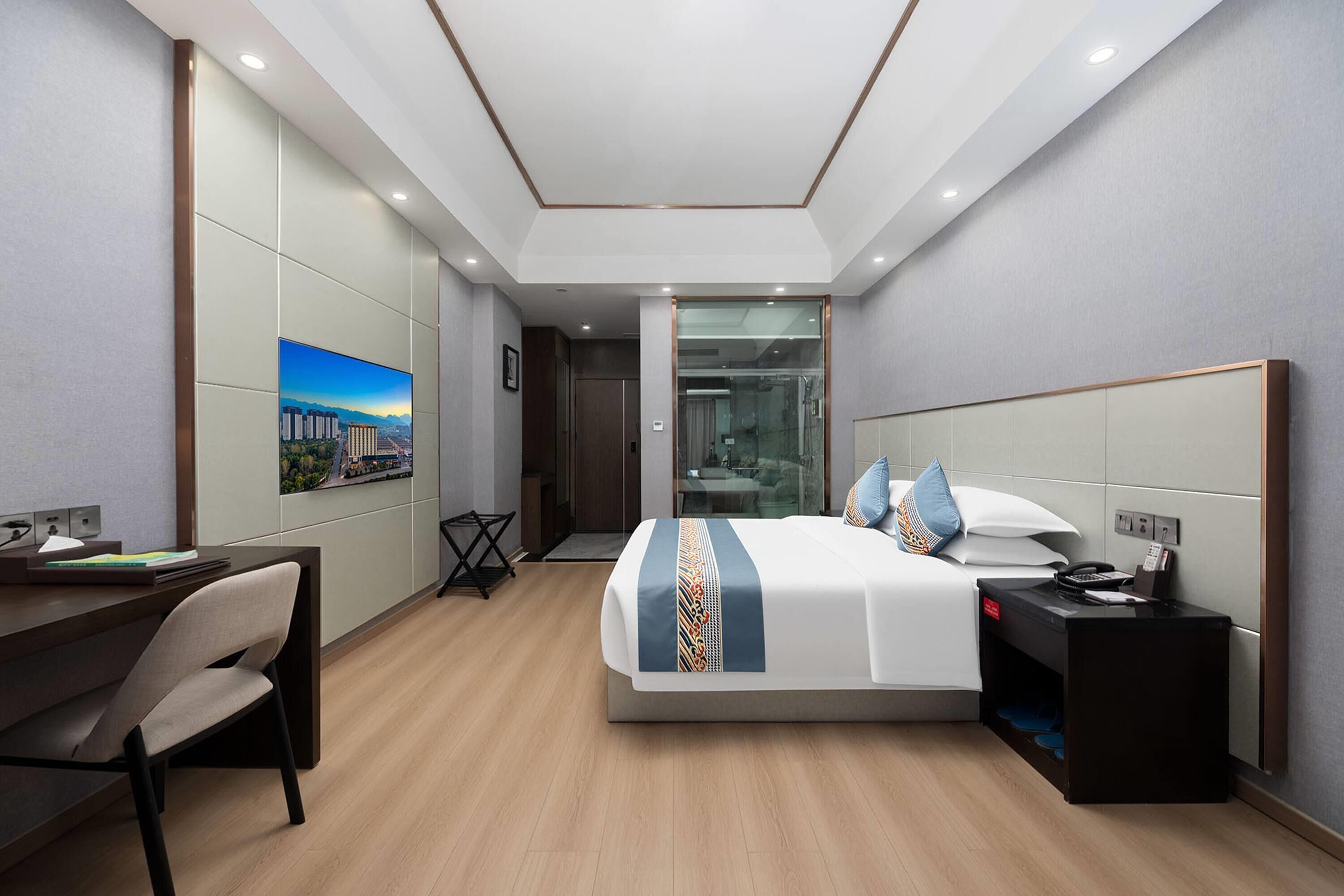 Una habitación de hotel moderna con una cama grande, un escritorio y una silla.