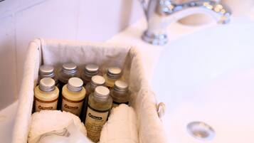 Un lavabo de salle de bain avec une serviette et des flacons de produits de la marque Touch Nature.