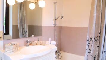 Baño con lavabo, espejo y ducha.