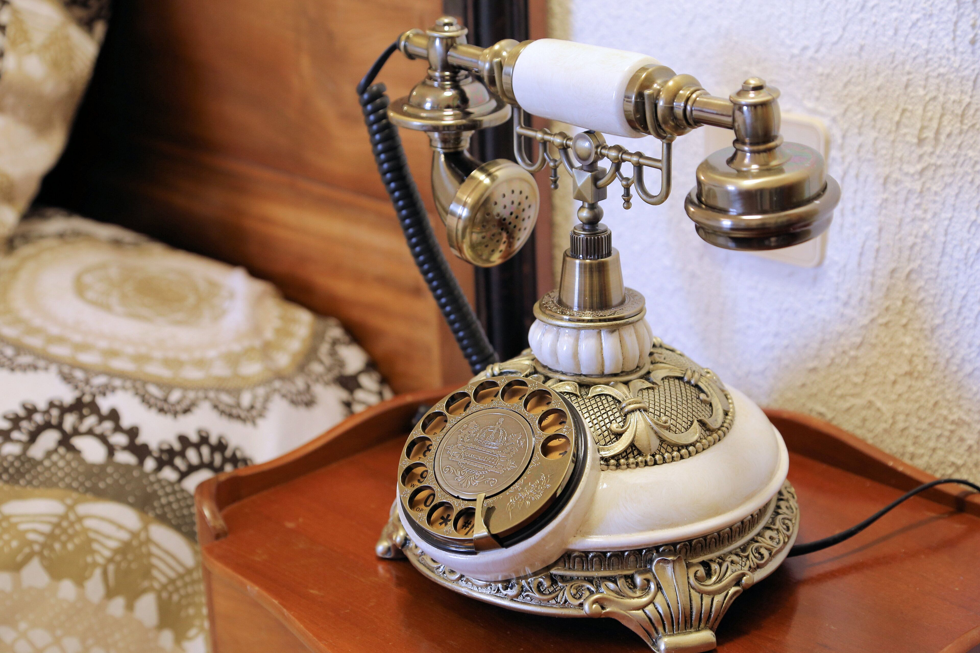 A vintage rotary dial telephone on a wooden tray.