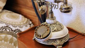 A vintage rotary dial telephone on a wooden tray.