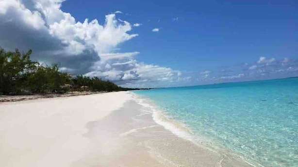 Una playa con agua turquesa cristalina y arena blanca.