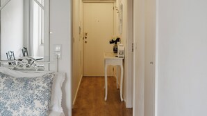 A bedroom with a bed, a bedside table, a mirror, and a door leading to a hallway. - Red House by the River (Porto)