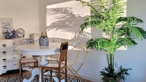 A dining area with a white table, wooden chairs, and a patterned rug. - Red House by the River (Porto)