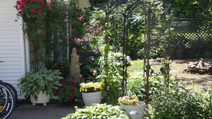 A garden with various potted plants and a trellis structure. - La Casa en Shediac (Shediac)