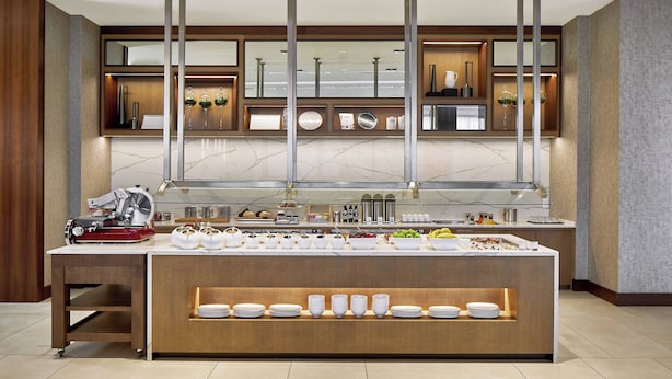 Une cuisine moderne dotée d’un plan de travail en marbre, d’une cuisinière encastrée et de divers appareils de cuisine.