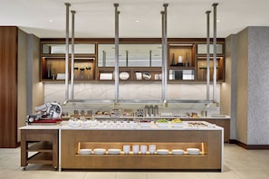 A modern kitchen with a marble countertop, a built-in stove, and a variety of kitchen appliances.