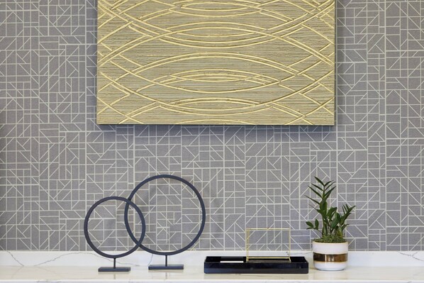 A wall with geometric patterned tiles and a decorative panel with intersecting lines.