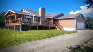 Et toetagers hus med en overdækket terrasse, garage og skorsten.