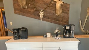 Et køkken med et hvidt skab, to kaffemaskiner og et skilt der siger "Coffee Bar".