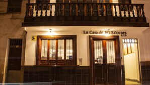 A building with a sign reading "La Casa de los Balcones" and a balcony with wooden railings.
