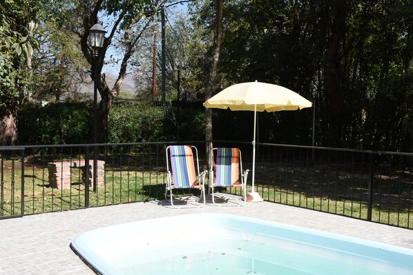 Utomhuspool, parasoller och solstolar