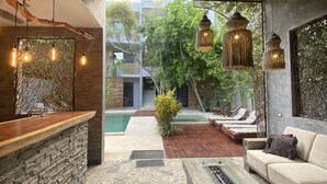 A modern reception area with a stone counter, patterned tiles, and a wooden bench. - Little Gem Hotel Tulum La Veleta (Tulum)