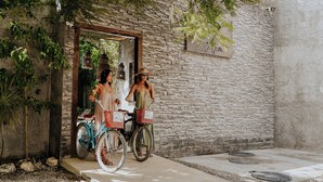 Two people exiting a stone-walled building with a sign that reads "love you". - Little Gem Hotel Tulum La Veleta (Tulum)