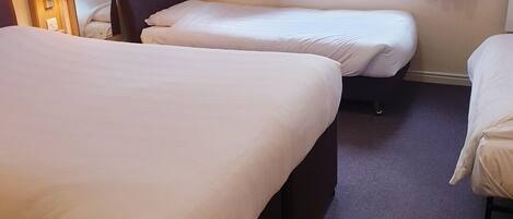A hotel room with two beds, a mirror, and a window with curtains.