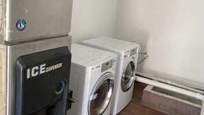 A laundry area with an ice dispenser and two washing machines. - The Village Inn (Denham Springs)