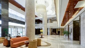 A spacious lobby with a marble floor, a central seating area with sofas and armchairs, and a large chandelier. - Li Cai Tian Qi Hotel Xianyang (Xianyang)