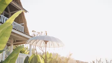 Ein Poolbereich mit Liegestühlen, einer Pergola und einem Gebäude mit Balkon.