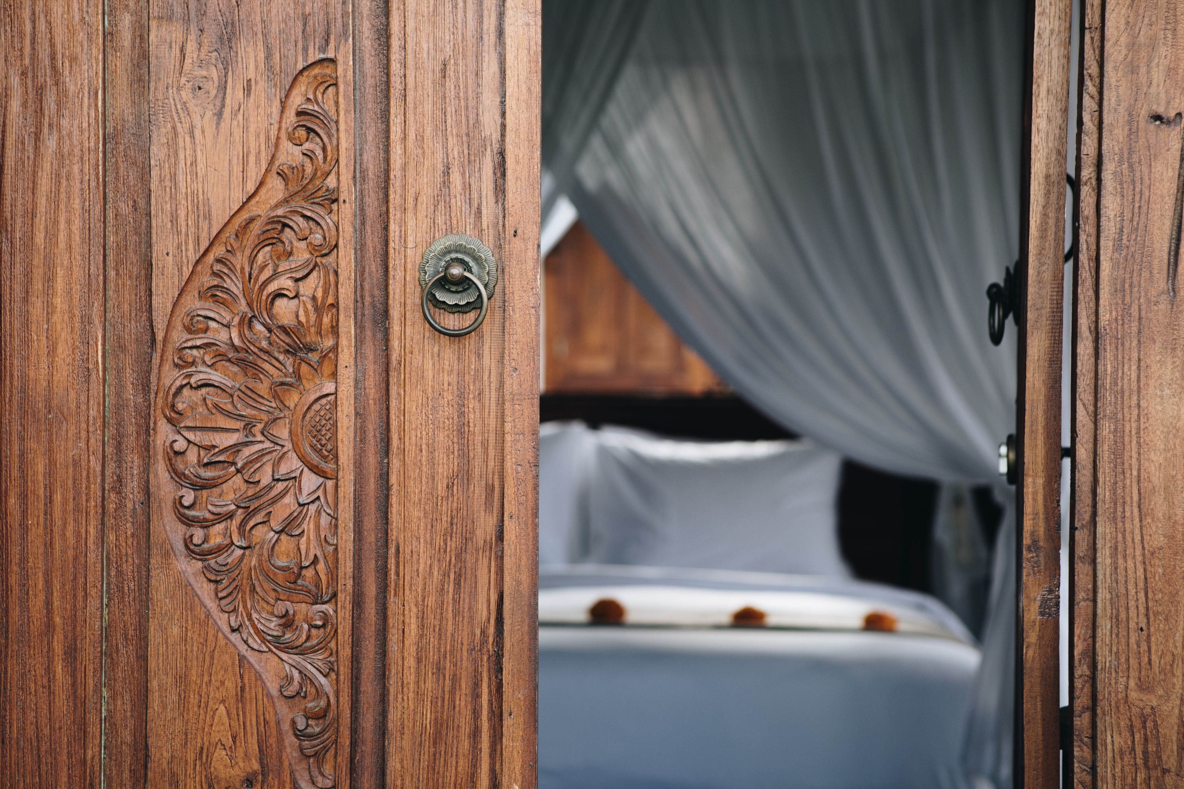 A wooden door with intricate carvings and a metal handle.