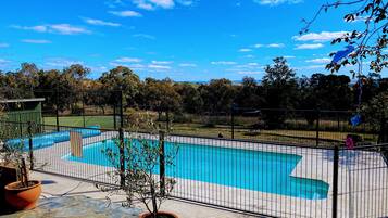 Relax by the pool surrounded by lush greenery and a serene atmosphere.