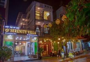 Um edifício de dois andares com uma placa indicando 'Serenity Villa'.