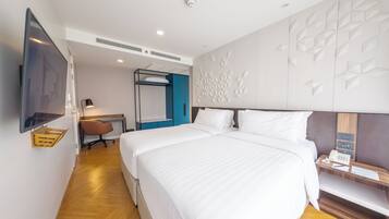 Ein modernes Hotelzimmer mit einem großen Bett, einem Schreibtisch mit Stuhl, einem flachbildfernseher an der Wand und einer dekorativen Wandverkleidung.