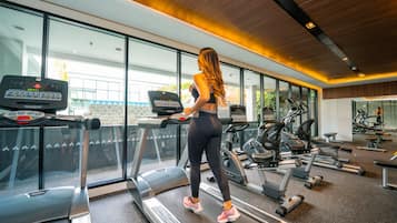 A modern gym with treadmills, exercise bikes, and weight machines.
