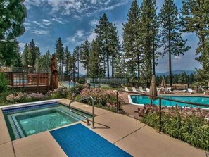 A pool area with a hot tub, lounge chairs, and a wooden deck. - Summer in Tahoe, Private neighborhood, Near, Lake, Beach, Pool,downtown&FUN 8max (Zephyr Cove)