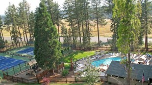 Área residencial com piscina, quadras de tênis e um quintal cercado.