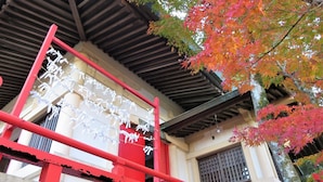A traditional Japanese building with a red wooden structure and a white wall. - Hostel Coliberty (Tokushima)