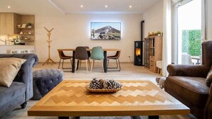 Una sala de estar moderna con comedor, chimenea y un ventanal grande.