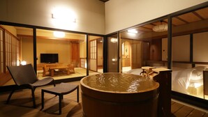 A traditional Japanese onsen with a wooden floor, a hot spring tub, and a seating area with chairs. - Yukemuri no yado Inazumi onsen (Yuzawa)