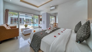 Ein modernes Schlafzimmer mit einem großen Bett, einer Sitzecke und einem Essbereich.