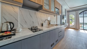 Eine moderne Küche mit Marmorarbeitsplatten, Holzschränken und einem eingebauten Gasherd.