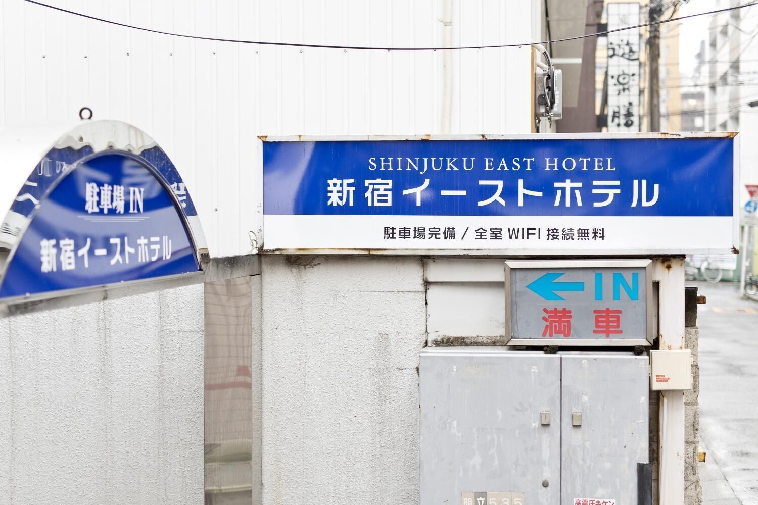 A hotel sign with Japanese text and a directional arrow.
