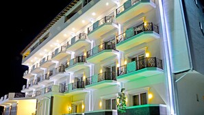 A multi-story hotel with balconies, a staircase, and a well-lit facade. - Monte Mare Hotel (Vlorë)