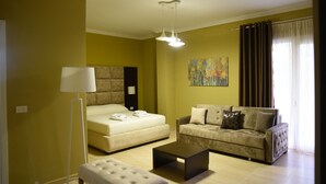 A modern living room with a bed, a sofa, a coffee table, and a floor lamp. - Monte Mare Hotel (Vlorë)