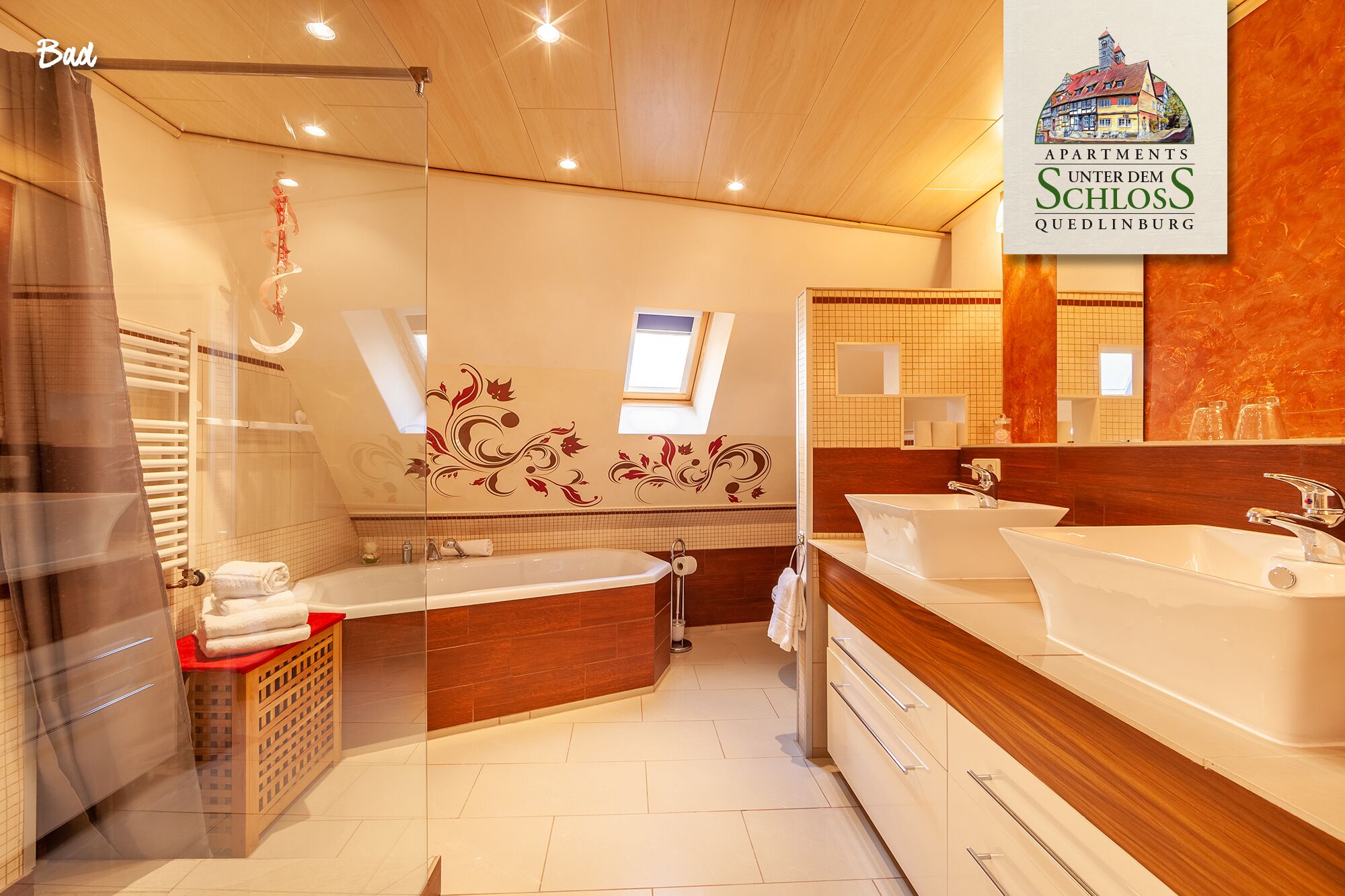 Ein modernes Badezimmer mit einer großzügigen Badewanne, zwei Waschbecken und einer separaten Duschkabine.