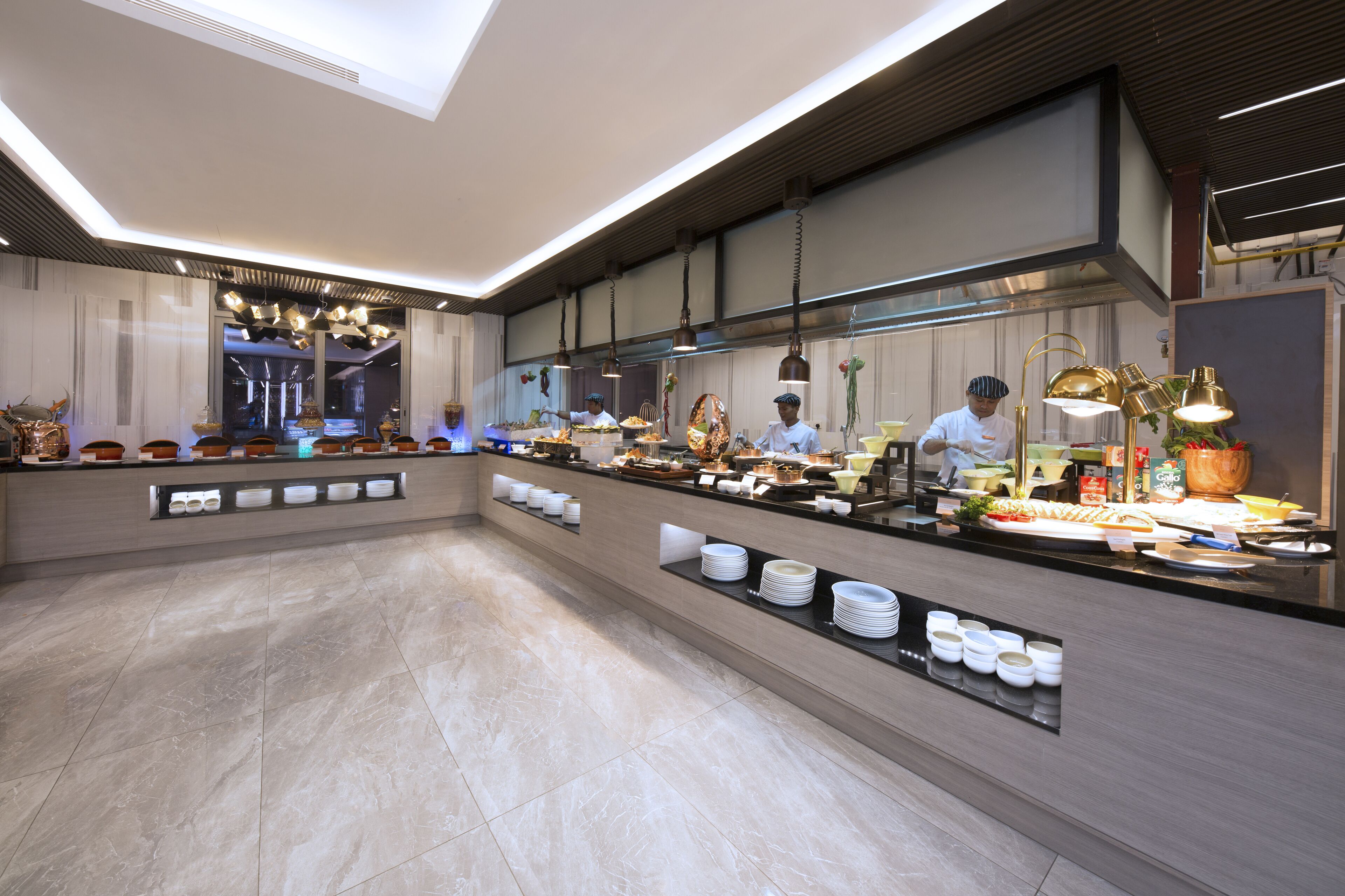 Un moderno vestíbulo de hotel con un espacio amplio, una recepción y vista a la cocina.