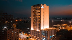 A high-rise hotel with multiple floors, illuminated windows, and a prominent sign. - Zealax Hotel & Residence (Yangon)