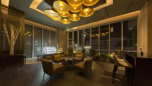 A modern lobby with a seating area, large windows, and a bar. - Zealax Hotel & Residence (Yangon)