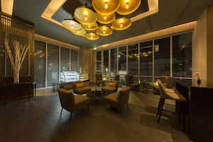 Un vestíbulo moderno con zona de estar, ventanas amplias y un bar.