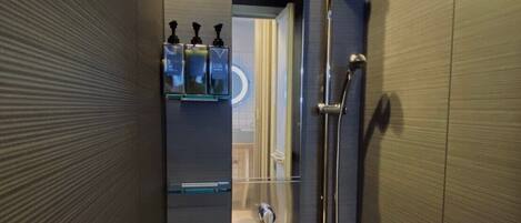 Une salle de bain moderne dotée d’une cabine de douche en verre, d’un sèche-mains et d’un porte-serviettes.