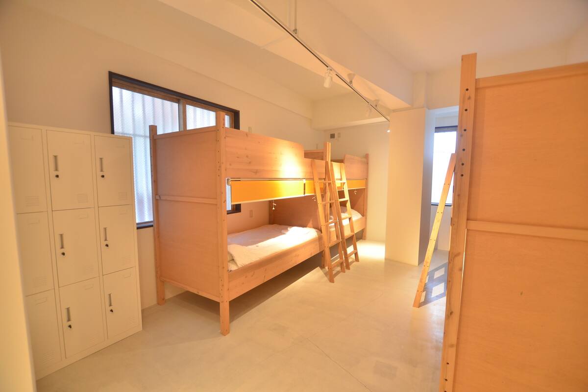 A room with bunk beds, a ladder, and a set of lockers.
