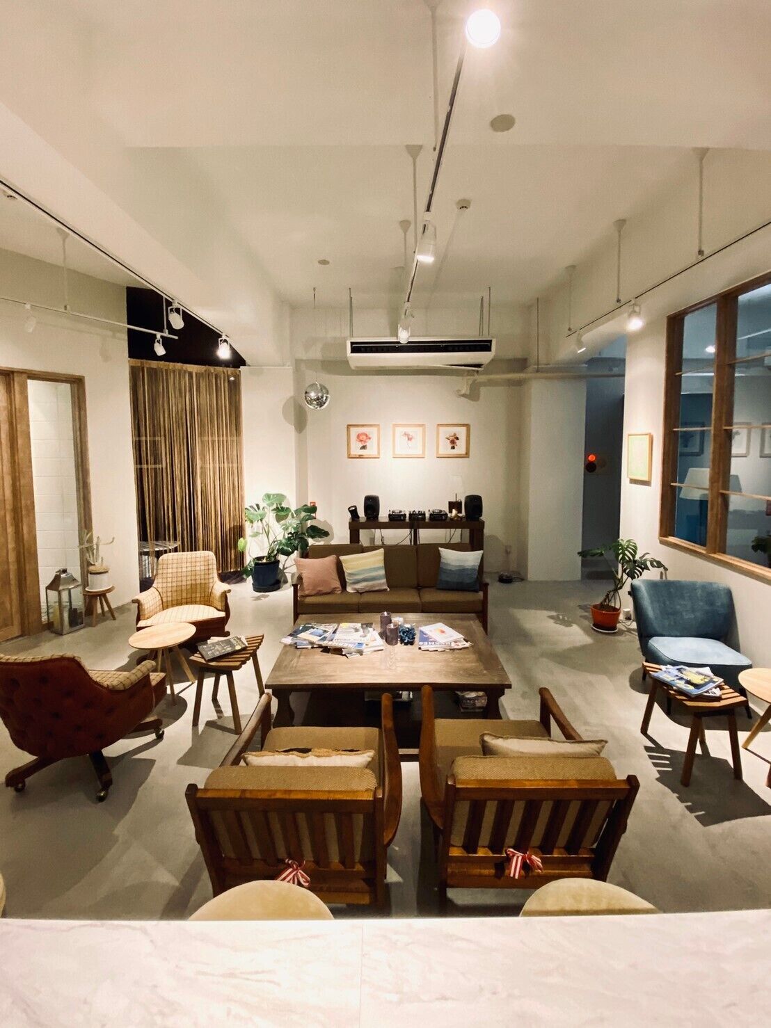 A modern living room with a central coffee table, seating area, and a large window.