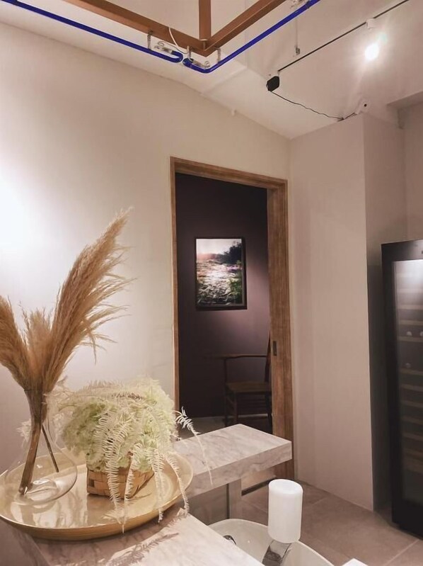 A modern interior with a marble table, a framed painting, and a potted plant.
