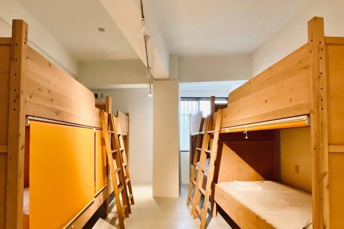 A dormitory room with bunk beds and wooden ladders.